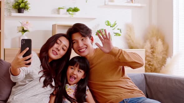 Asian family are calling on smartphone. All happy using cellphone for video call, smiling family hav alt