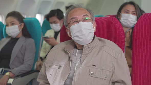 Group of passengers wearing face mask sitting at seat in airplane