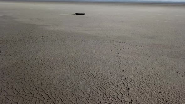 Top View of Boat at Shore of Dried Up Sea Global Warming and Drought Concept alt