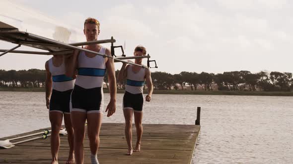 Male rower team carrying the boat on their shoulders alt