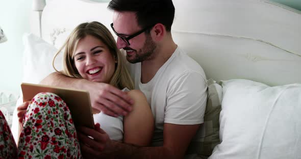 Romantic Couple in Kissing and Smiling in Bed