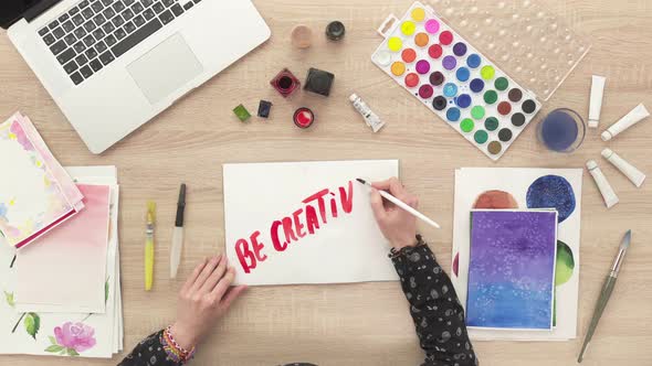 Girl's hands painting a lettering phrase, Creative background, Watercolor artist workspace