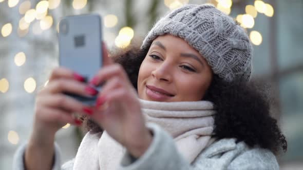 Beautiful African American Woman is Taking Selfie Using Phone Standing Outdoors Spbi alt