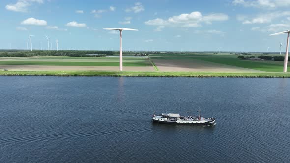 Recreational Leisure Boat Sailing Along Coast with Wind Turbines alt