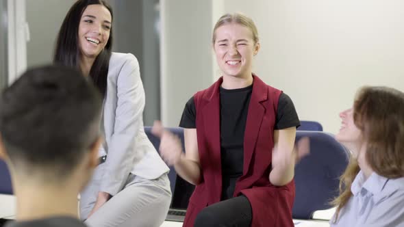 Cheerful Laughing Colleagues Sitting in Office Talking alt
