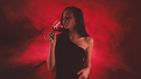 Woman with Glass of Red Wine in Red Smoke