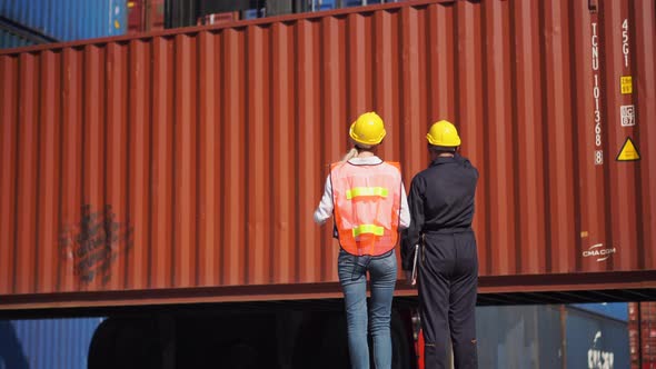 Engineer and foreman team control loading containers box at cargo, Logistic concepts