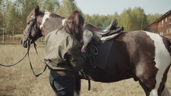 An Experienced Rider After Riding a Horse Unharnesses It, Loosens the Girths Under the Saddle alt