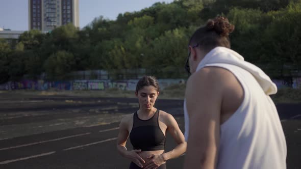 The Guy Shoots a Video on the Camera a Girl Athlete on a Summer Day alt