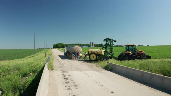Tractor pesticide spraying getting tank filled up with insecticide. Aerial. Series alt