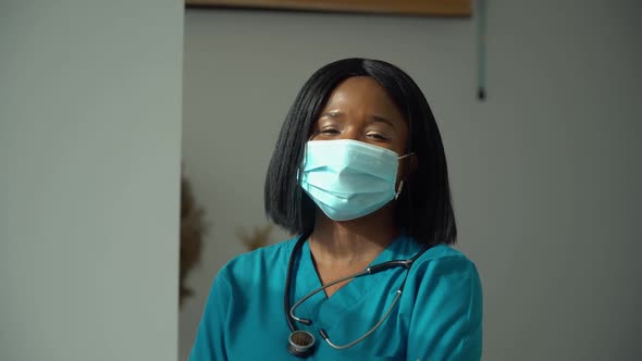 Young African Woman Doctor in Blue Protective Mask Looking at the Camera alt