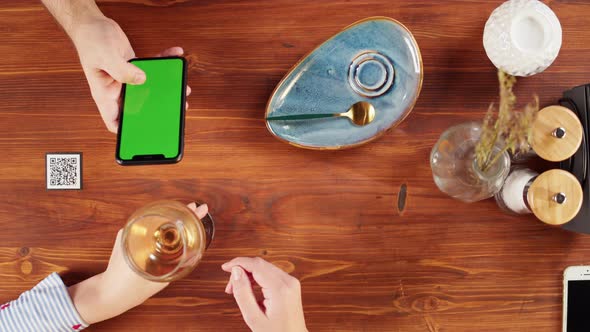 Woman Using Smartphone with Chroma Green Screen Top View Online Menu in Cafe alt