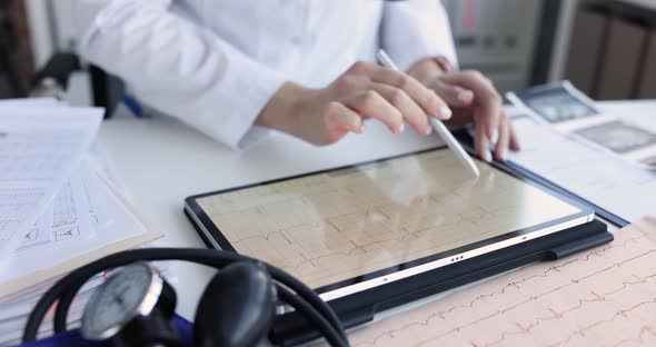 Cardiologist Examines Electrocardiogram on Tablet in Cardiology Clinic alt
