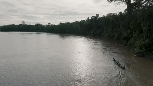 Aerial sunny day shot of beautiful boat sailing in the river with surrounded forest . alt
