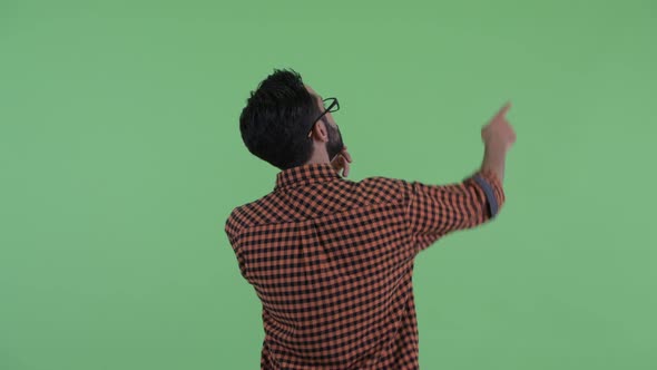 Rear View of Young Bearded Persian Hipster Man Pointing Finger alt
