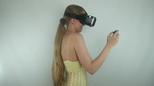 Woman Uses A Virtual Reality Helmet And A Gamepad In A Simulation Game