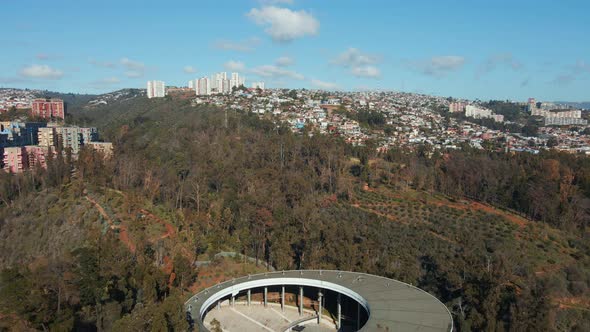 Aerial dolly out of Quinta Vergara Amphitheater and Park surrounded by autumnal trees, Viña del Mar alt