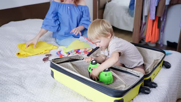 Children Travel, Joyful Darling Little Male Kid Has Fun with His Caring Female Parent Collect