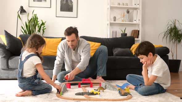 Dad and Children Spend Weekend Together at Home Parent and Two Kids Playing Toys
