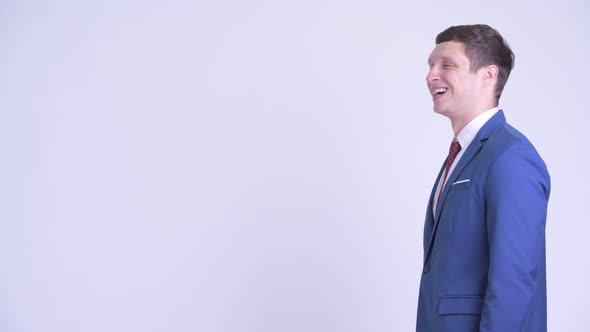 Profile View of Happy Young Handsome Businessman Smiling alt