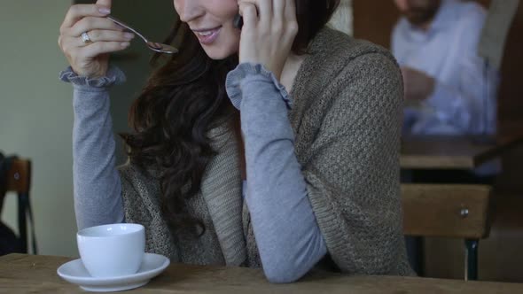 CU TU Young woman drinking coffee and talking on mobile phone / Breda, NoordBrabant, Netherlands.