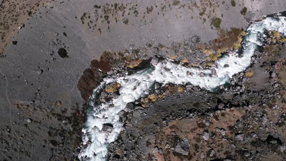 Aerial Drone Shot descending on a small River on Arid terrain, Cordillera de los Andes, Chile-4K alt