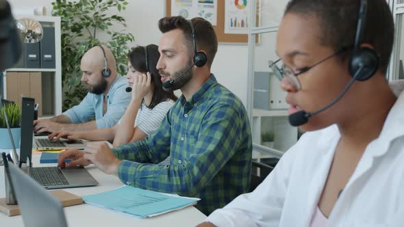 Business Team Working in Call Center Consulting Customers Online Talking and Smiling Using Computers alt