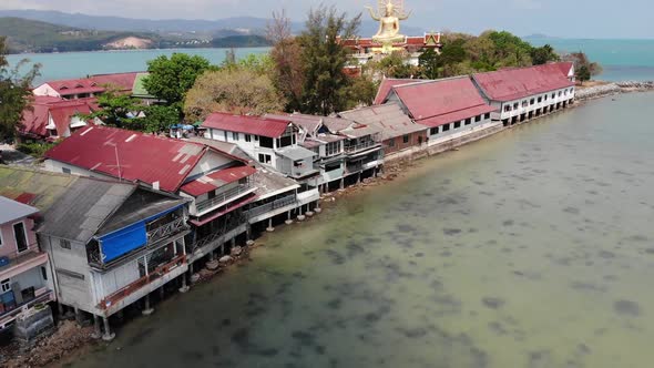 Island with Buddhist Temple and Many Houses. Aerial View of Island with Buddhist Temple with Statue alt