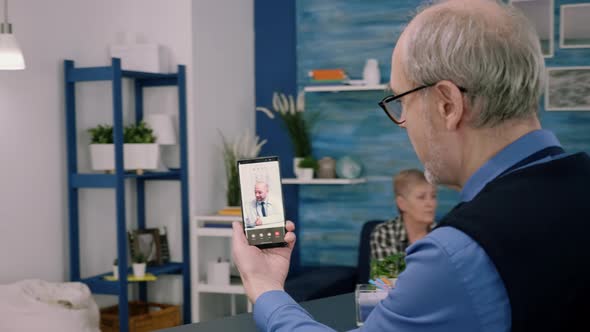 Senior Business Man Discussing During Video Conference with Remote Doctor alt