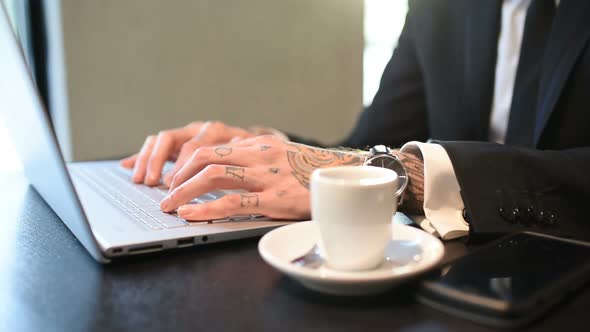 close up tattooed hand young businessman using computer alt