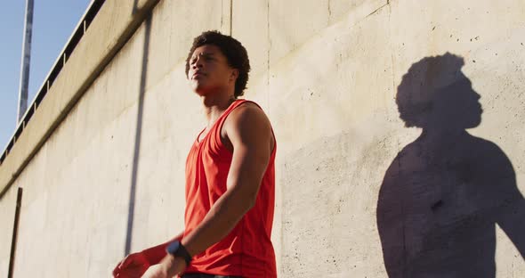 Fit african american man exercising outdoors in city, bouncing basketball alt