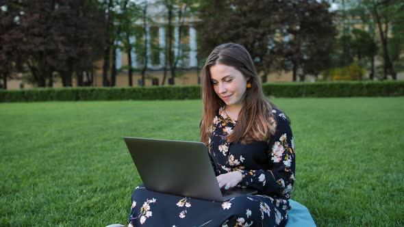 Beautiful Woman Using Laptop in the Outdoor Park. alt