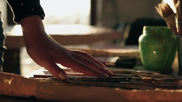 Close Up Footage of Accurately Manicured Female Hand Choosing Brush From a Row on the Table alt