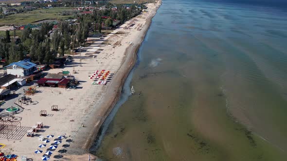 Beautiful flight in summer over the beach. People are resting near the sea.