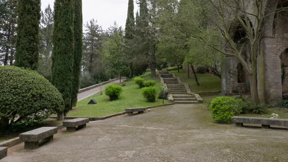Park with a Stone Wall Benches and Stairs with Saturated Vegetation Near Cathedral of Girona Spain