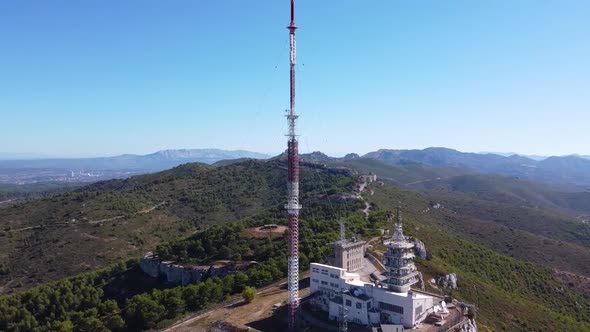 Drone Shot (rotating and close up) of a Radio Station on top of an Arid Hill under a Midday Sun alt