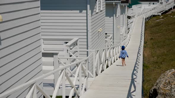 Boy Child in a Striped Blue Jacket and Bandana Walks alt
