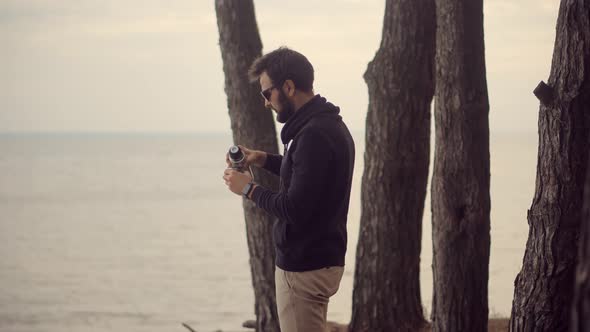 Tourist Man Drinking Hot Tea From Thermo Cup. Businessman Drinking Tea Or Coffee And Enjoys View. alt