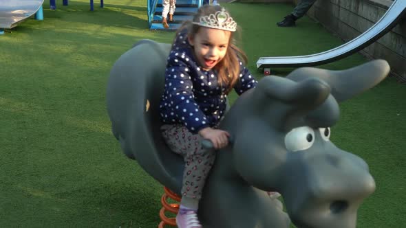Medium Plan Portrait of One Cute Little Sibling Child Preschool Girl Having Fun Swinging On Swing alt