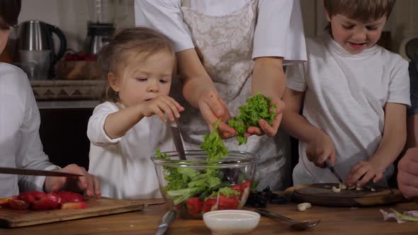 Happy Family with Three Kids Is Cooking Salad at Home Together