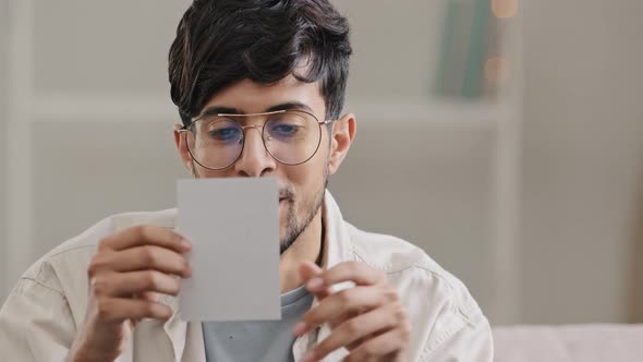 Portrait Young Arabic Man Bearded Ecstatic Guy with Glasses Sits at Home Indoors Receives Envelope alt