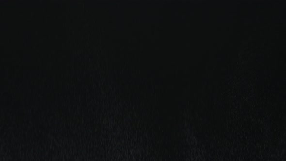 Heavy Angled Rain Falling in Front of the Camera Against Black Screen. Raindrops Splashing. Rain alt