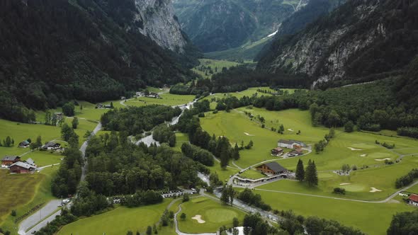 Drone Tilts Up From Alpine Mountain Meadows and Chalet Houses To Reveal Epic Snowy Peaks Ridge in alt