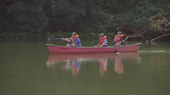 Kids at summer camp paddling a canoe