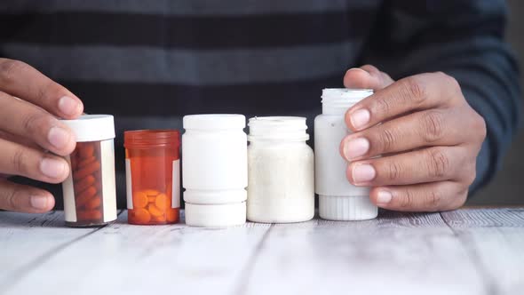 Young Man Hand Holding Many Medicine Pill Container White Sited alt