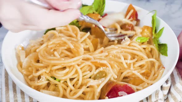 Step by step. Serving a one-pot pasta into a white pasta plate. alt