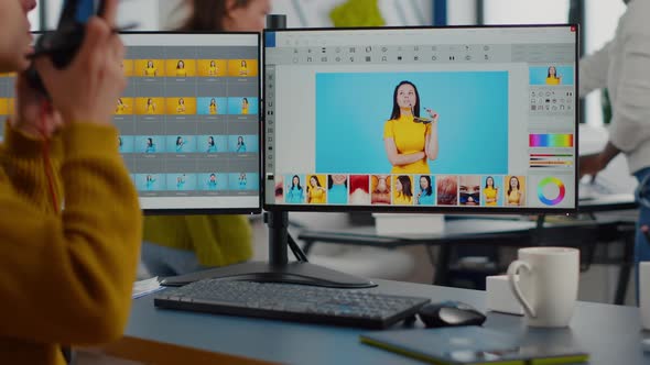 Professional Photographer Sitting at Desk Putting on Headphones alt