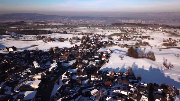 Panorama flight over a village with a church not far from the lake of Zurich. alt