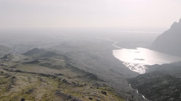 Drone Over Man Looking Down Into Sunlit Valley alt