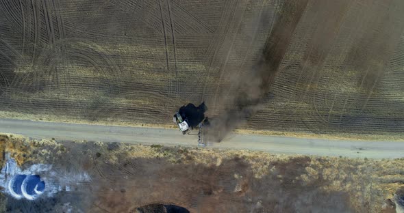 Aerial view of tractor moving on harvested field 4k alt